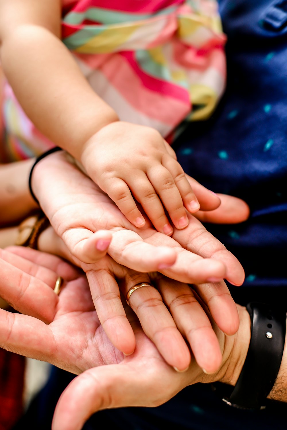 Person, die eine schwarze Uhr trägt und Babys Hand hält