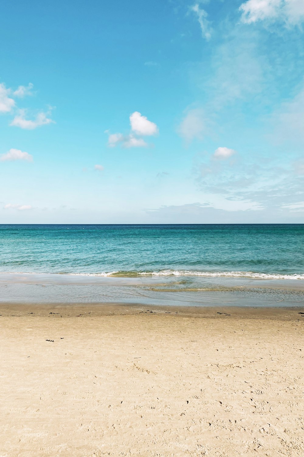 blaues Meer unter blauem Himmel und weiße Wolken tagsüber