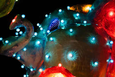 Close-up of colorful sculptures made from recycled metal and plastic, glowing under soft gallery lights.