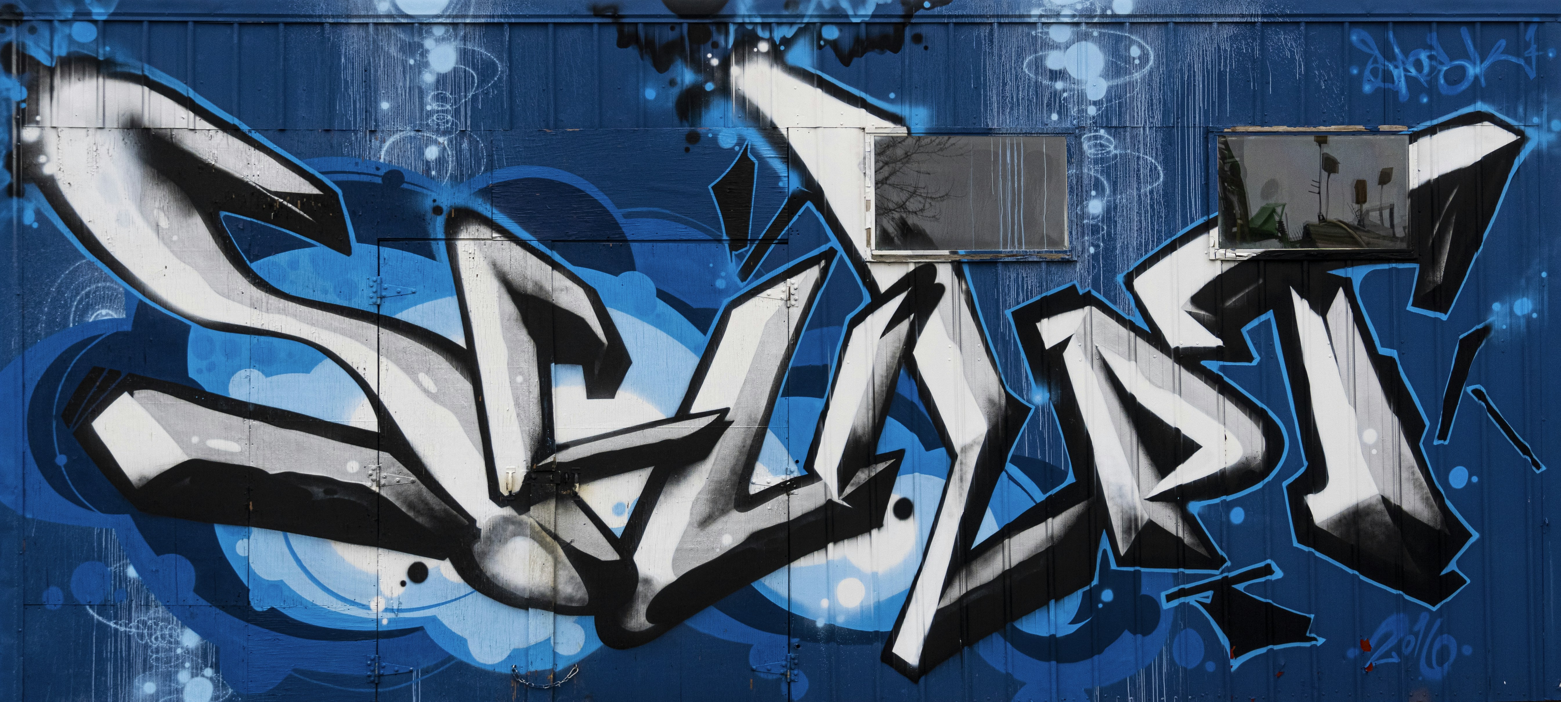 blue and white graffiti on wall