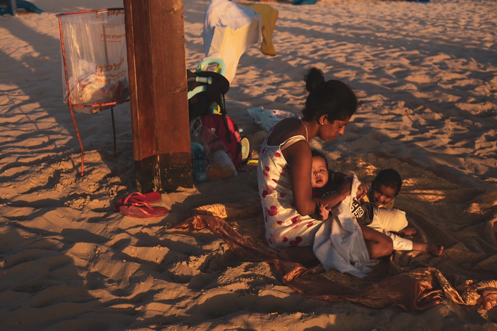 2 boys lying on brown sand during daytime