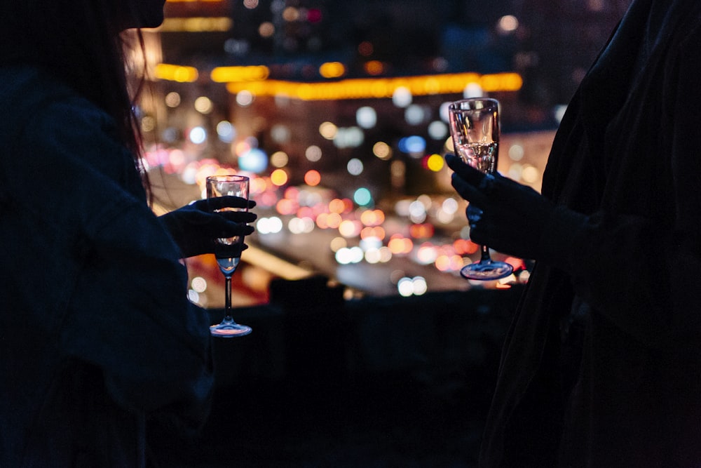 Frau hält Weinglas mit Bokeh-Lichtern