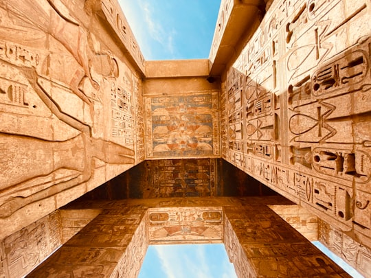 low angle photography of brown concrete building under blue sky during daytime in The Theban Necropolis Egypt