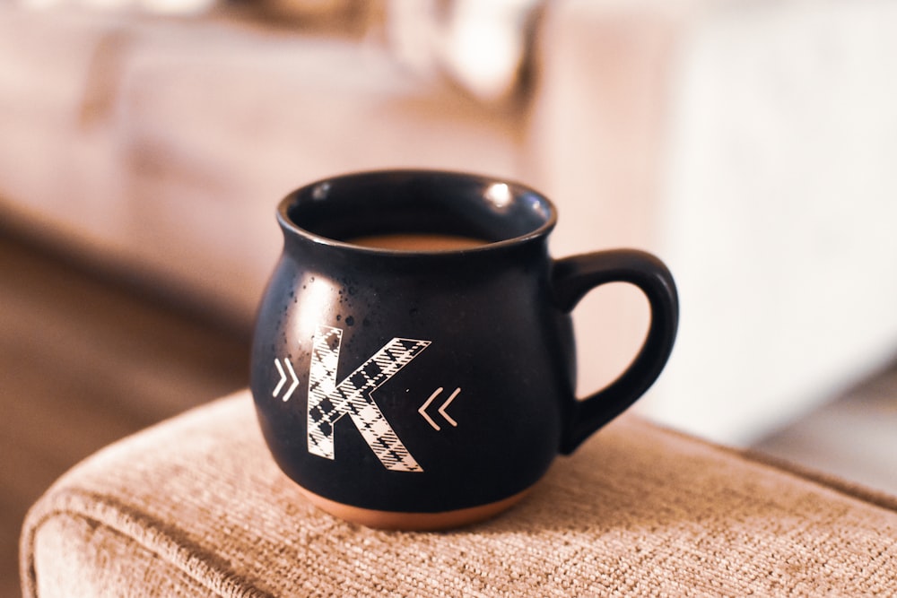 black and white ceramic mug on brown wooden table