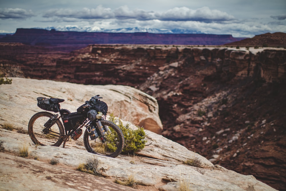 black mountain bike on brown rock formation during daytime