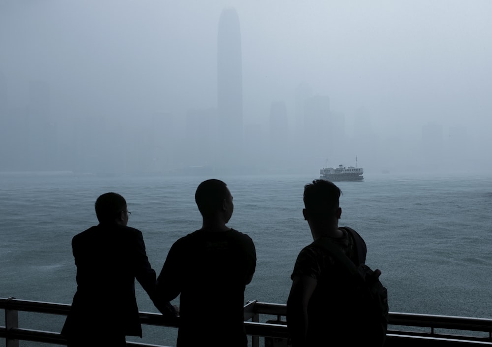 a group of people standing next to each other near a body of water