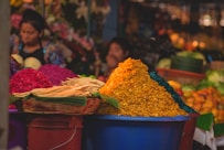 yellow and pink flowers in blue plastic bucket