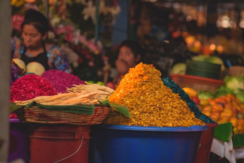 yellow and pink flowers in blue plastic bucket