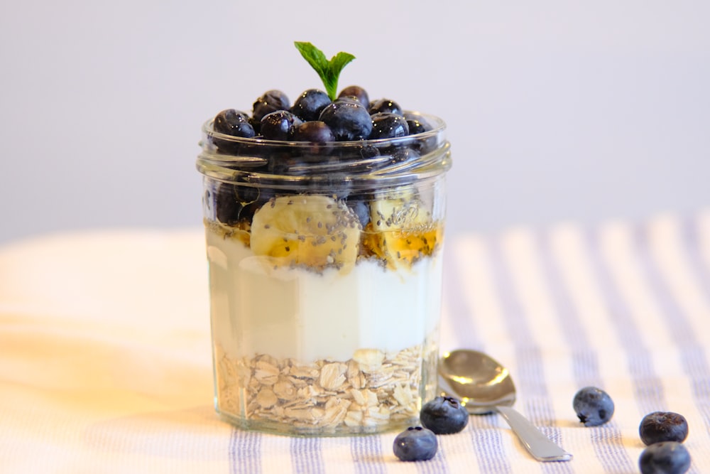 ice cream in clear glass cup beside stainless steel spoon