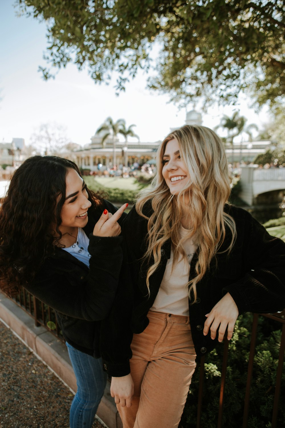 2 women standing on bridge during daytime