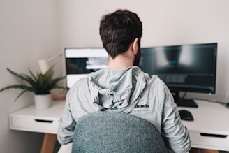man in gray hoodie sitting on chair
