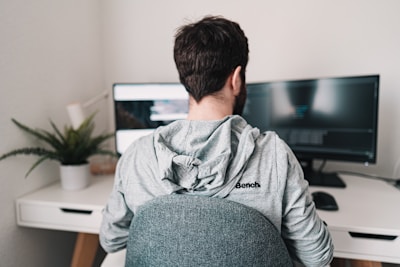 man in gray hoodie sitting on chair