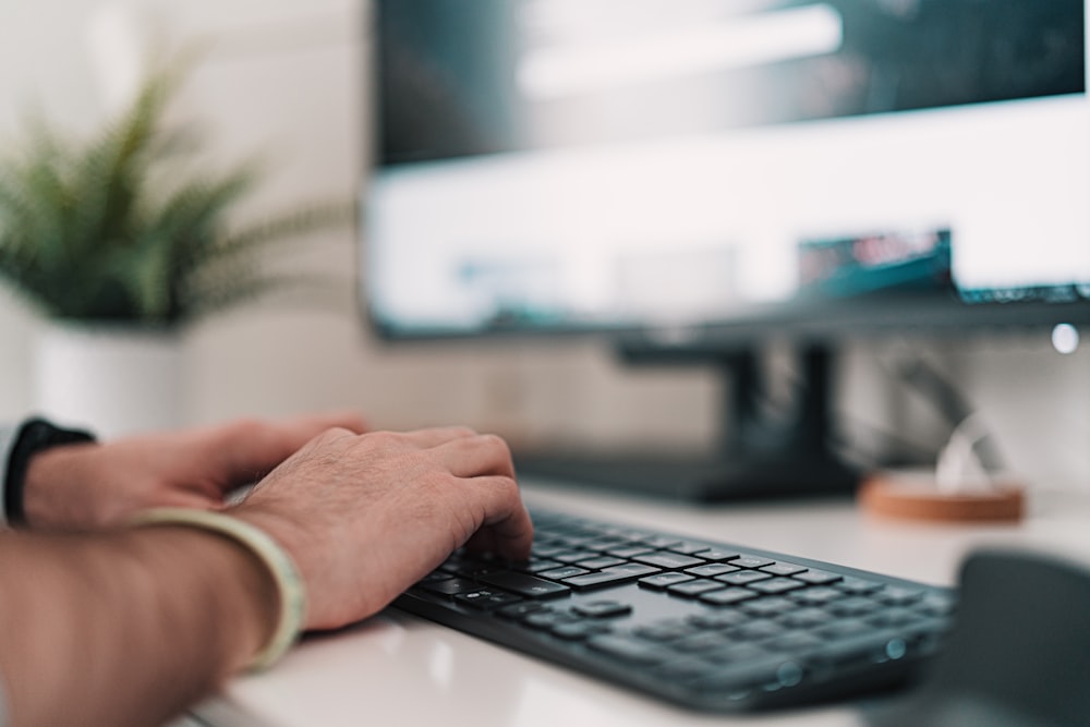 person using black and silver computer keyboard