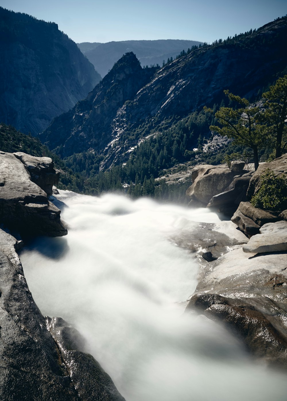 river between green mountains during daytime