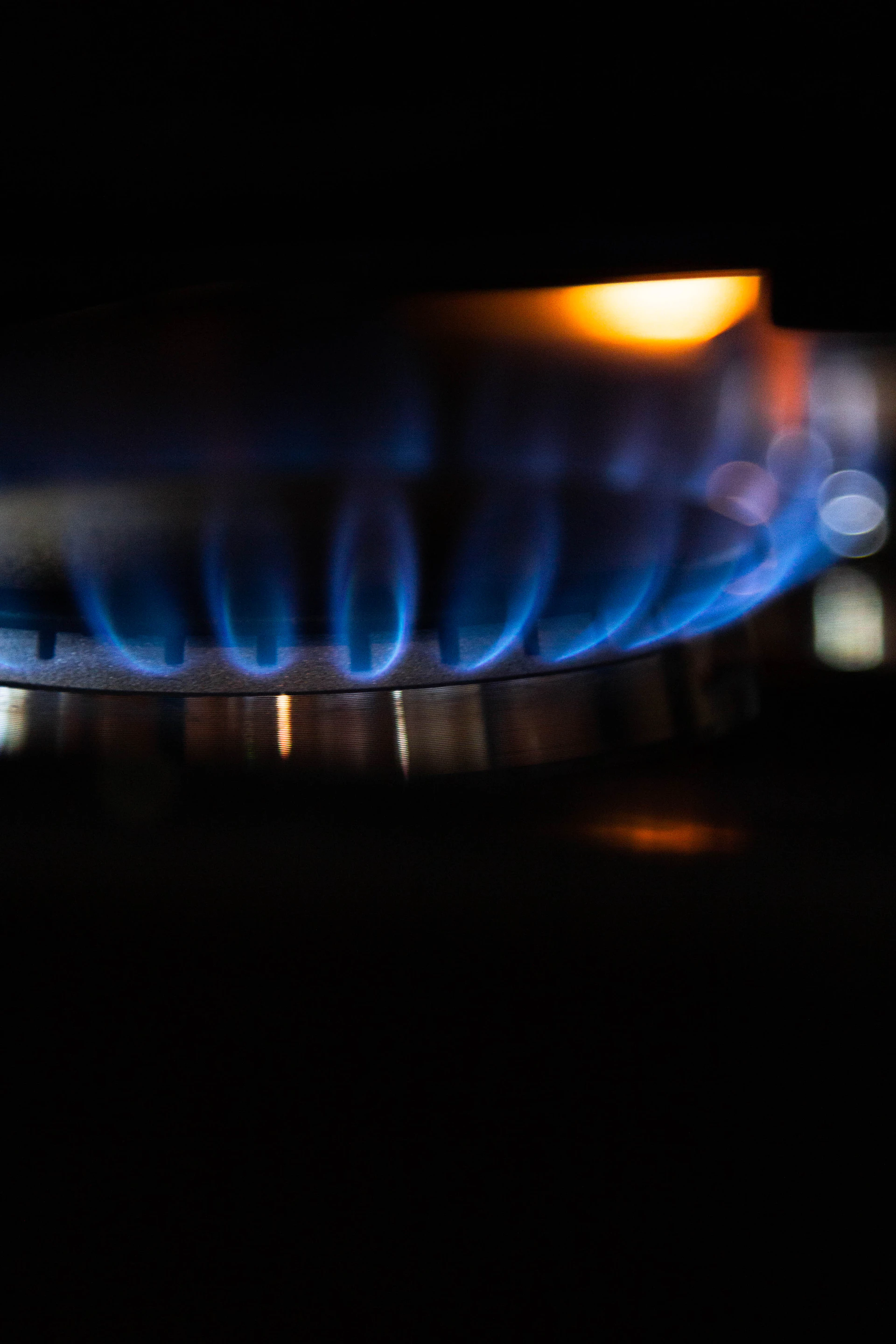 A blue gas flame burning steadily in the dark