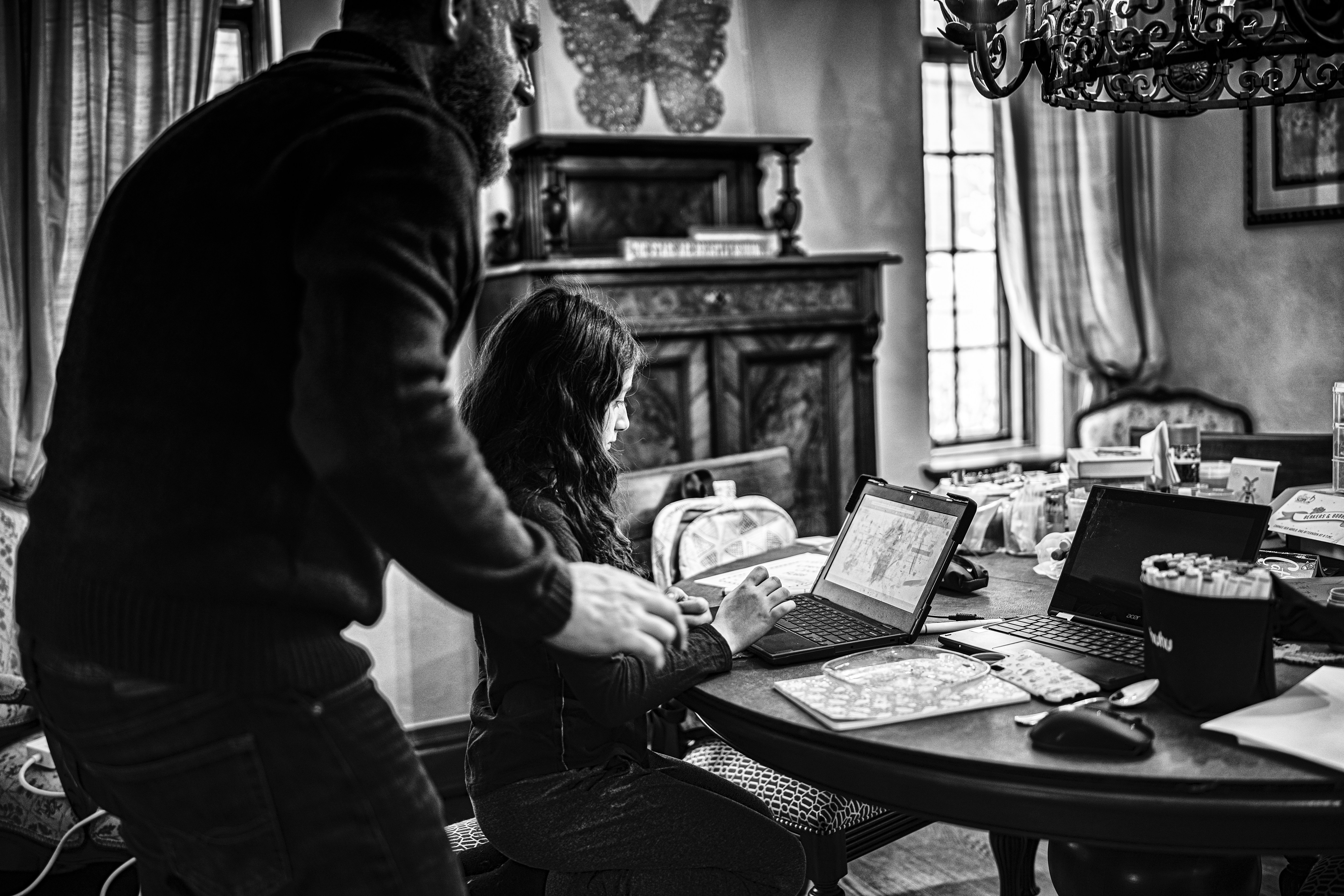 grayscale photo of woman in long sleeve shirt holding book