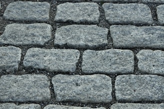 A close-up of a freshly installed stone driveway with clean, precise interlocking patterns.