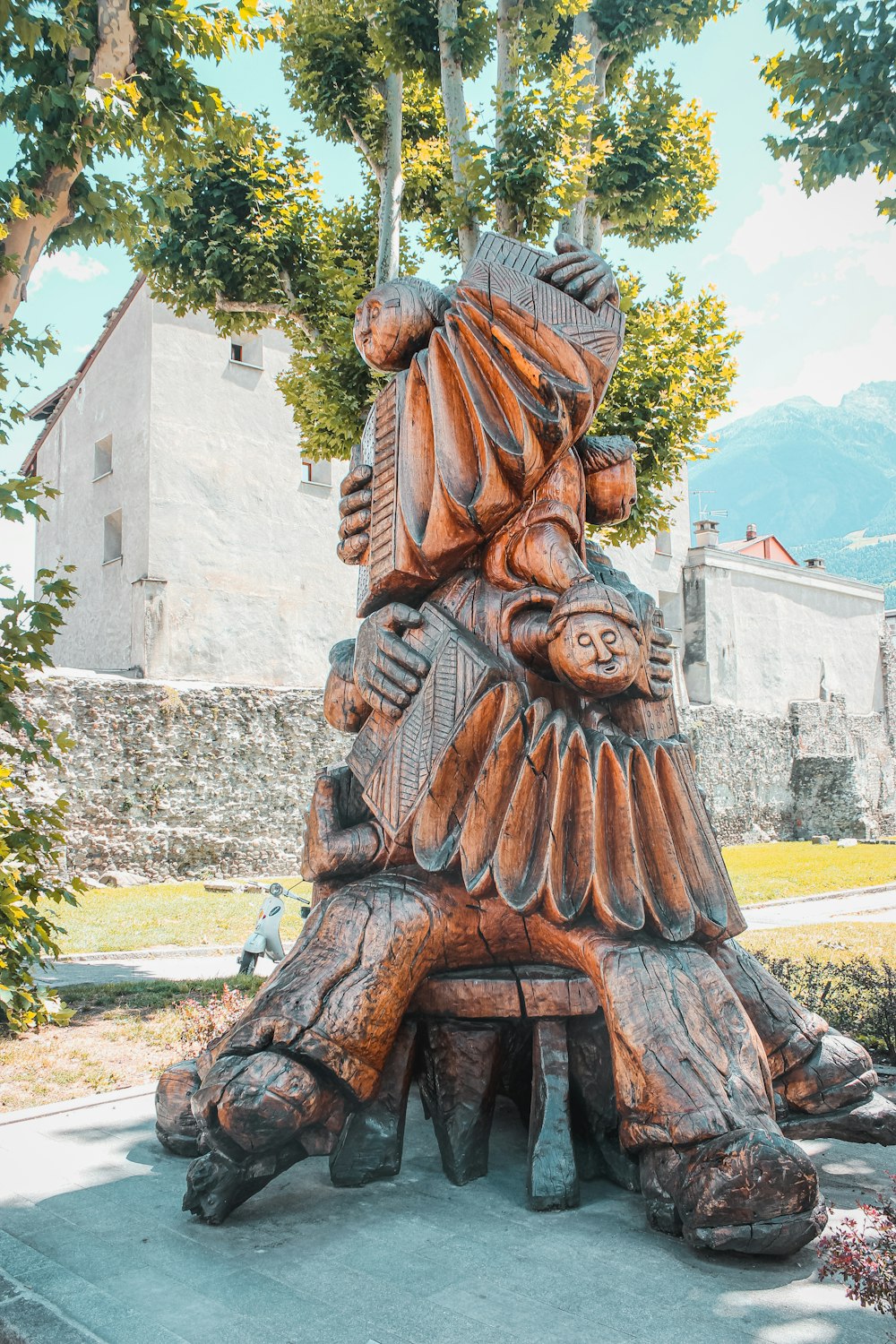 brown wooden statue near green trees during daytime