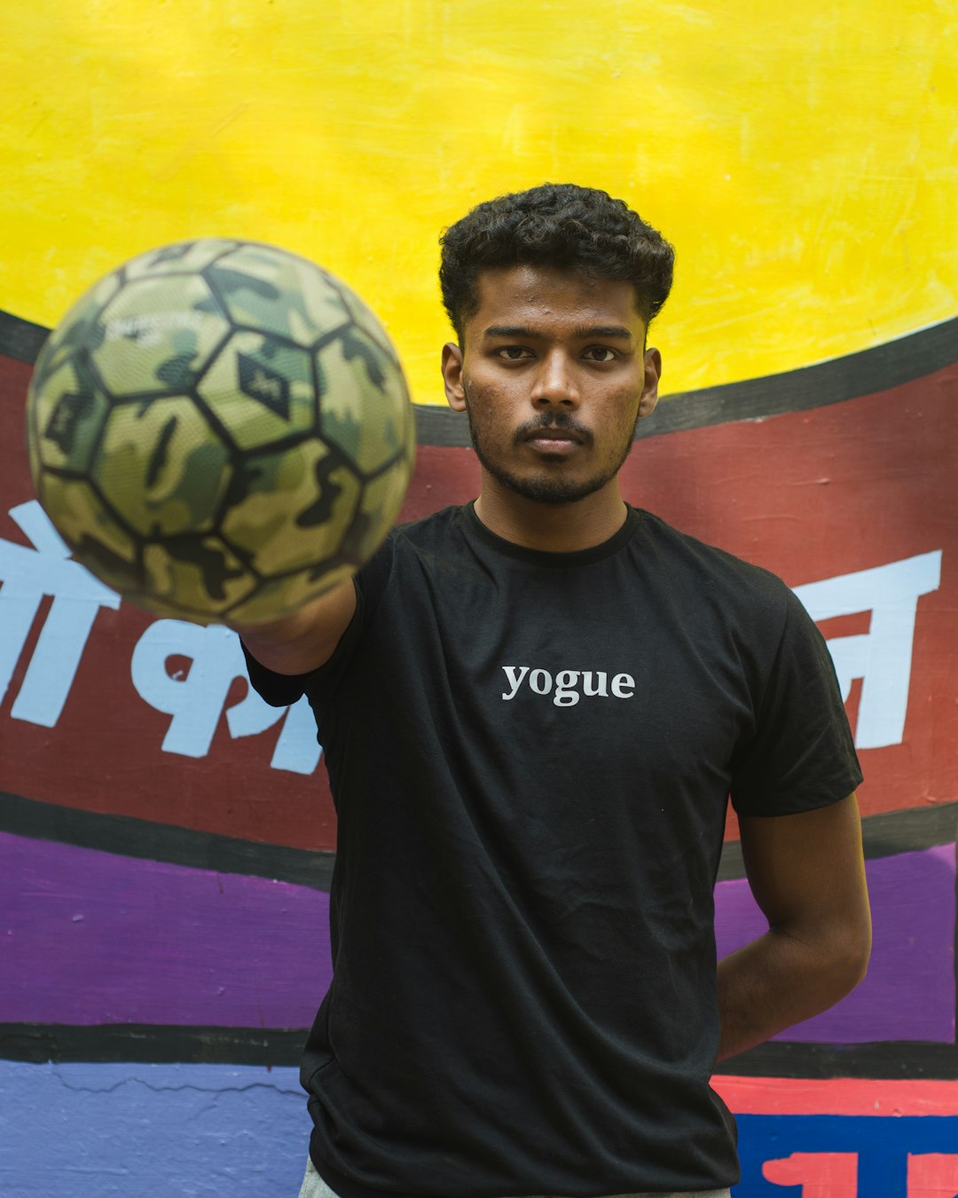 man in black crew neck t-shirt holding soccer ball