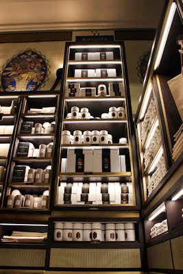 A neatly arranged display of packaged biscuits and cookies on a wooden shelf with soft natural light.