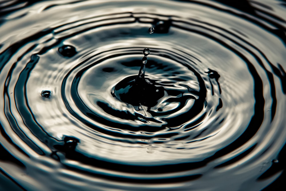 water drop on water in close up photography