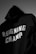 A black hoodie with the words 'REIGNING CHAMP' printed in bold white letters on the back. The fabric appears soft and heavy, casting a shadow in a dimly lit environment.