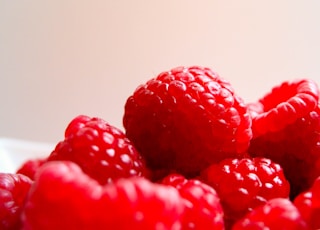 red raspberries on white ceramic bowl