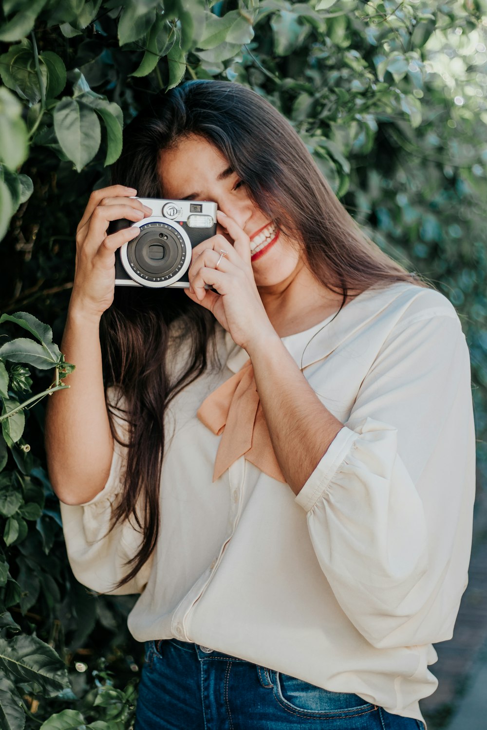 woman in white dress holding black and silver camera