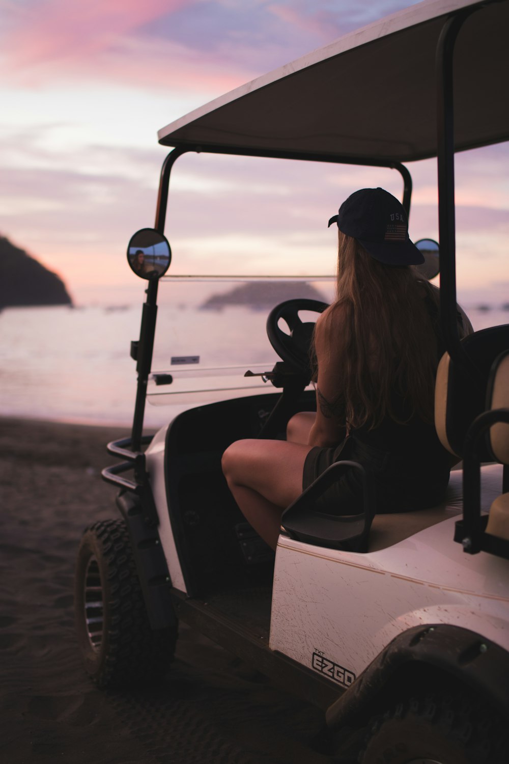 femme en débardeur noir équitation sur une voiturette de golf blanche et noire pendant la journée