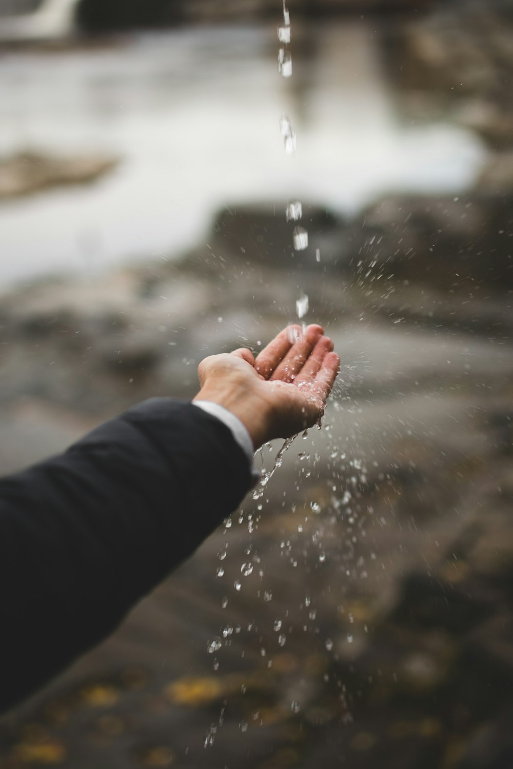 person in black long sleeve shirt holding water