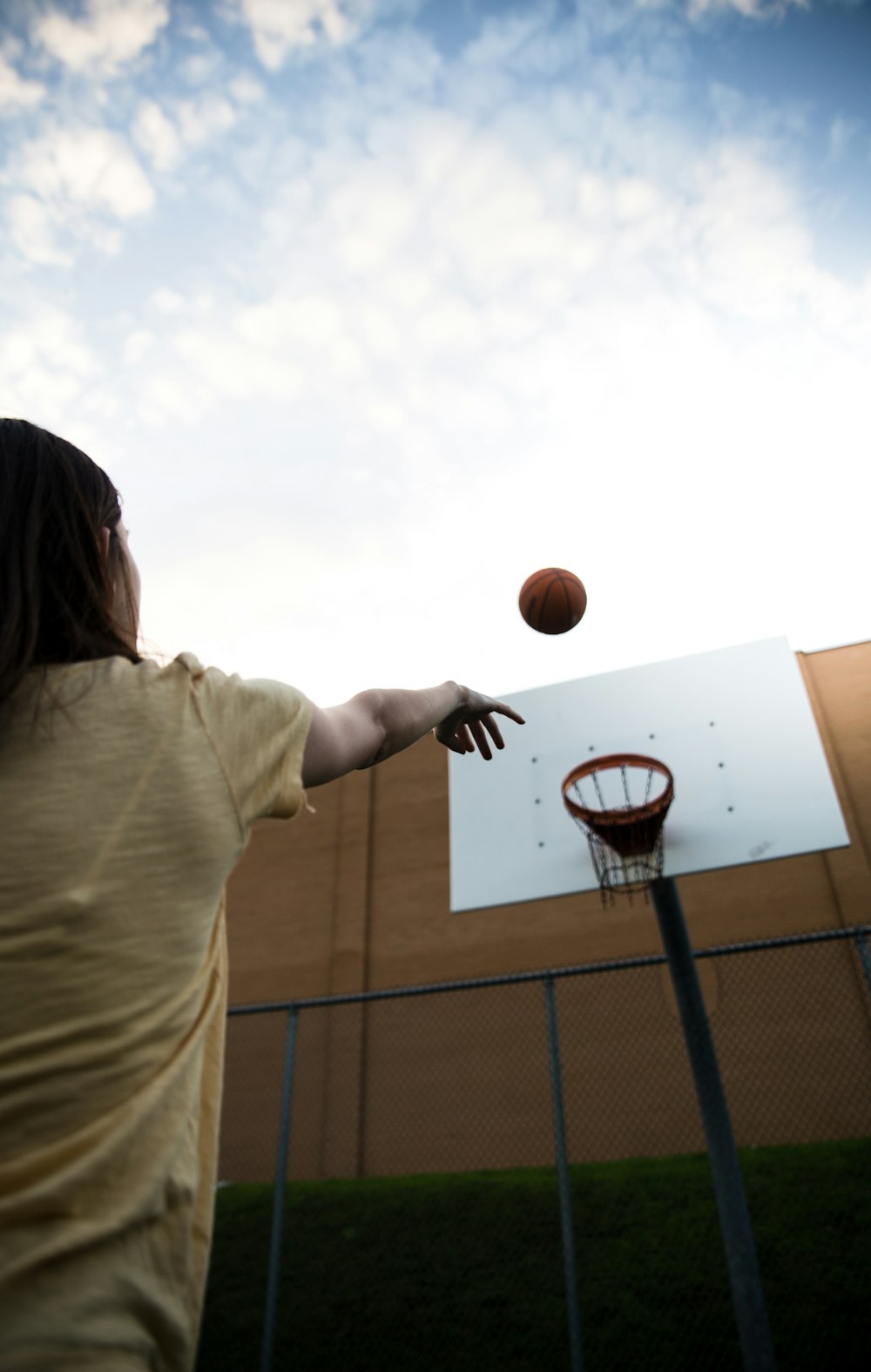Frau im weißen Hemd hält Basketball