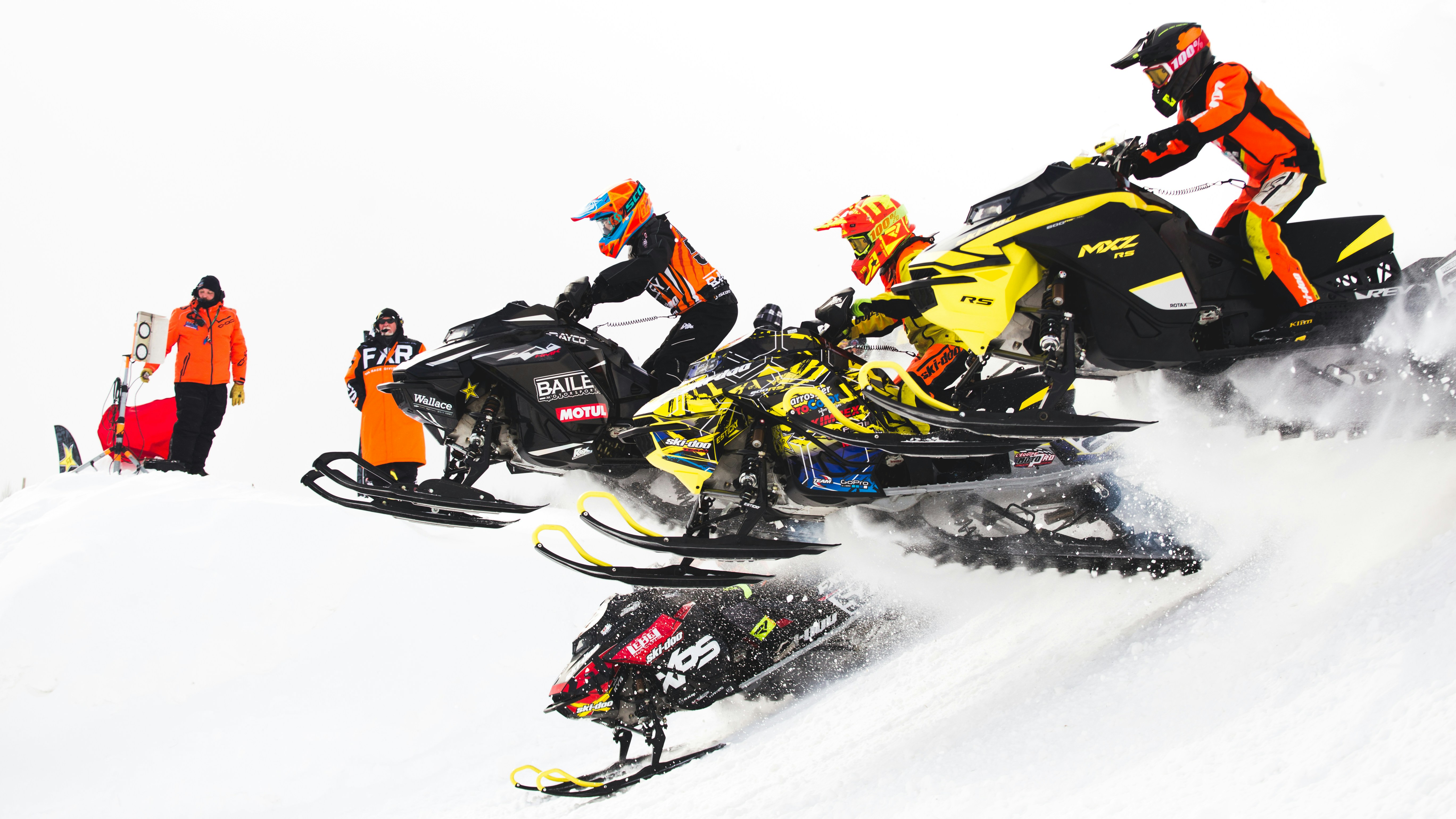 people riding snow ski on snow covered ground during daytime