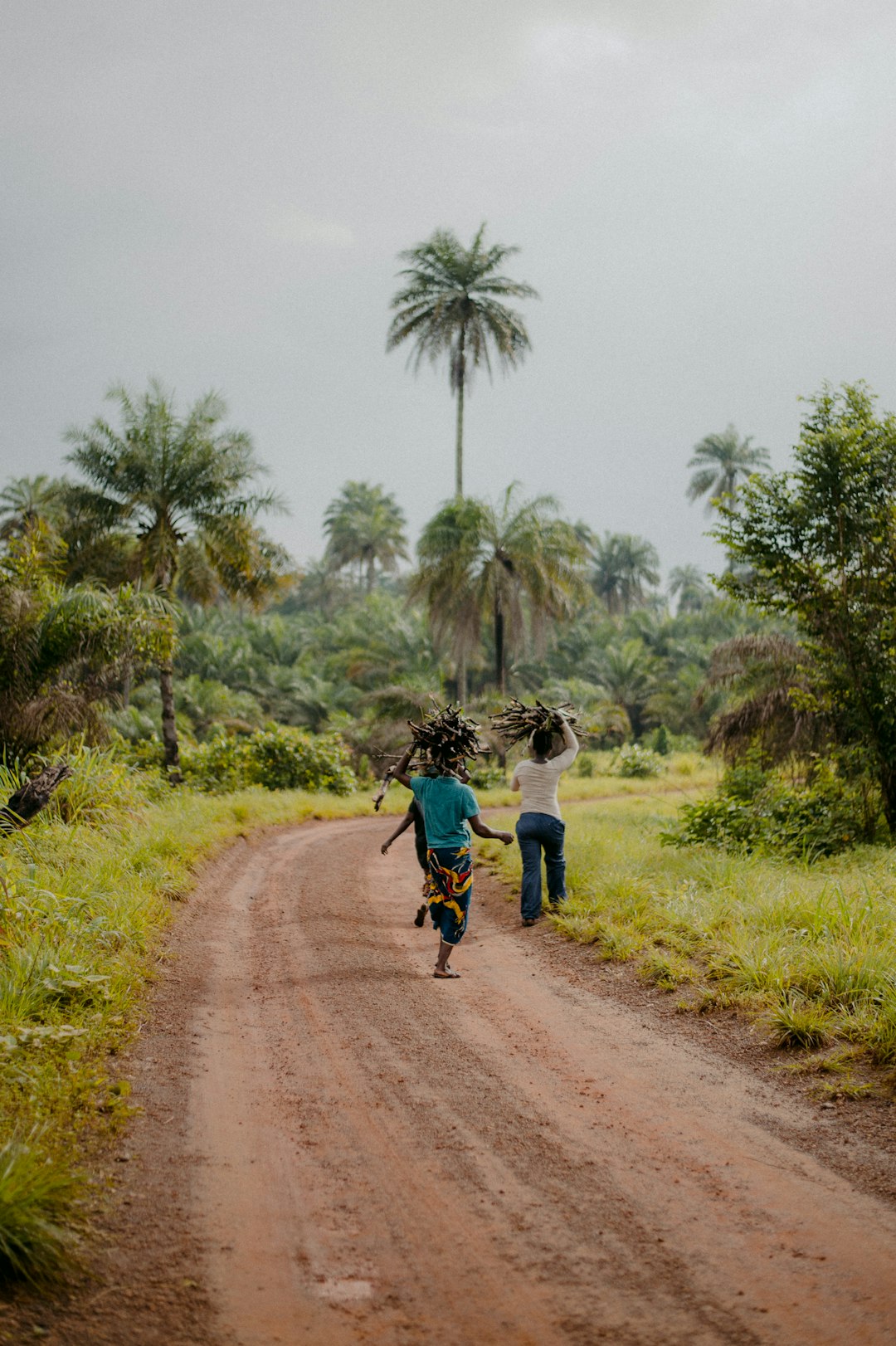 man in blue shirt and black pants walking on dirt road during daytime