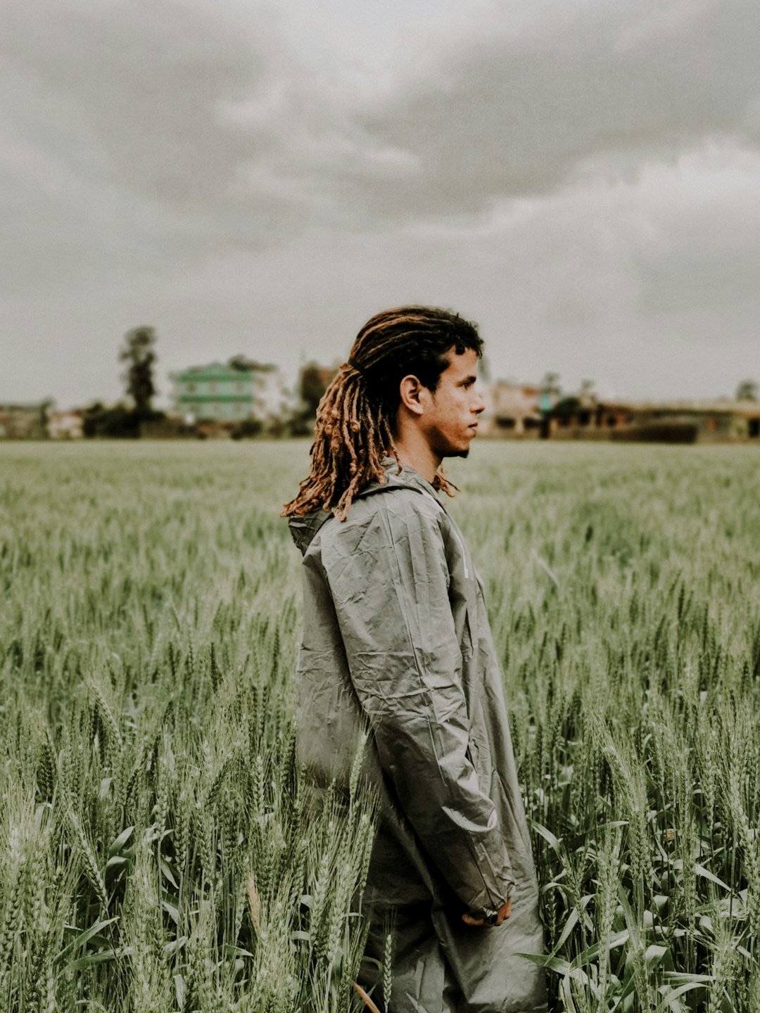 woman in grey denim jacket standing on green grass field during daytime