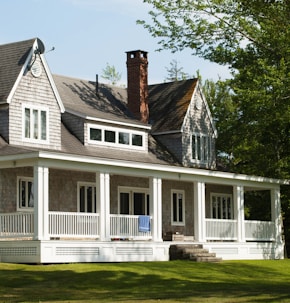 white and brown wooden house near green trees during daytime