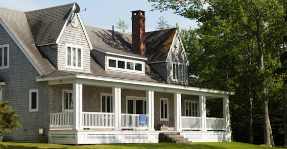 white and brown wooden house near green trees during daytime