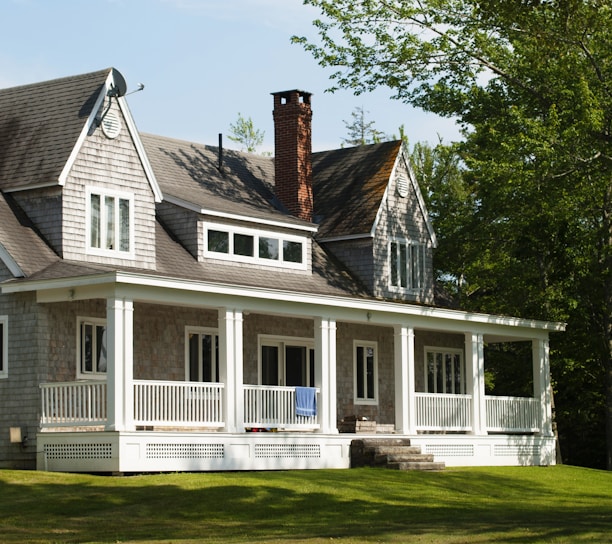 white and brown wooden house near green trees during daytime