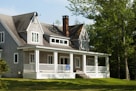 white and brown wooden house near green trees during daytime