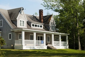 white and brown wooden house near green trees during daytime