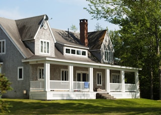 white and brown wooden house near green trees during daytime