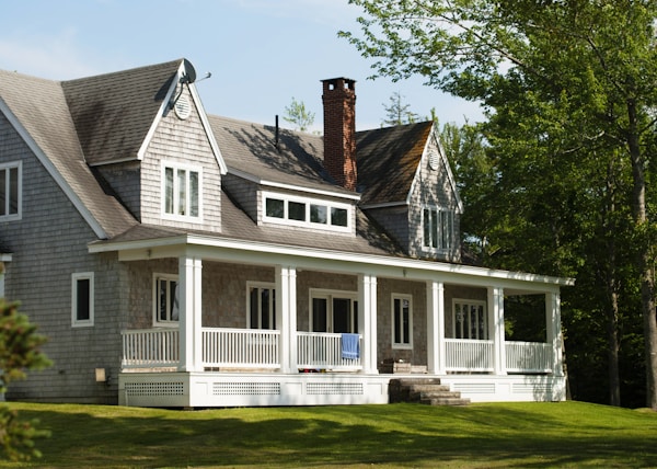 white and brown wooden house near green trees during daytime