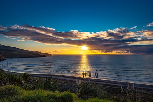 sea under blue sky during sunset in Raglan New Zealand