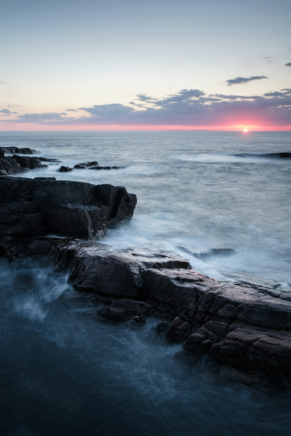 black rocky shore during sunset