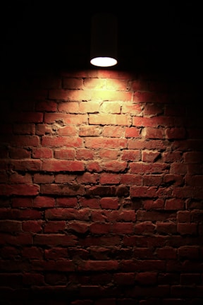 Evening photo of a completed brick wall with warm lighting highlighting textures