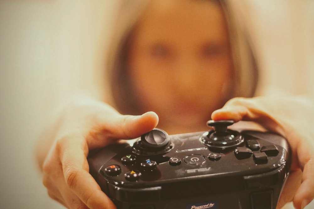 person holding black sony ps 4 controller