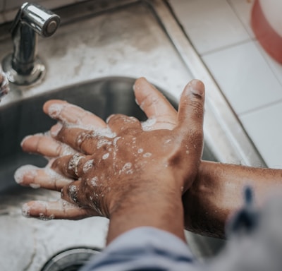 person in white shirt washing hands