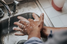 person in white shirt washing hands