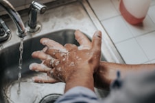 person in white shirt washing hands