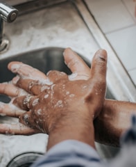 person in white shirt washing hands