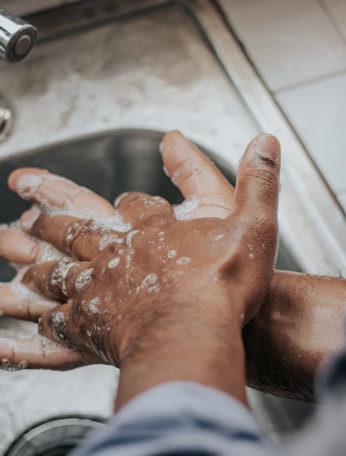 person in white shirt washing hands